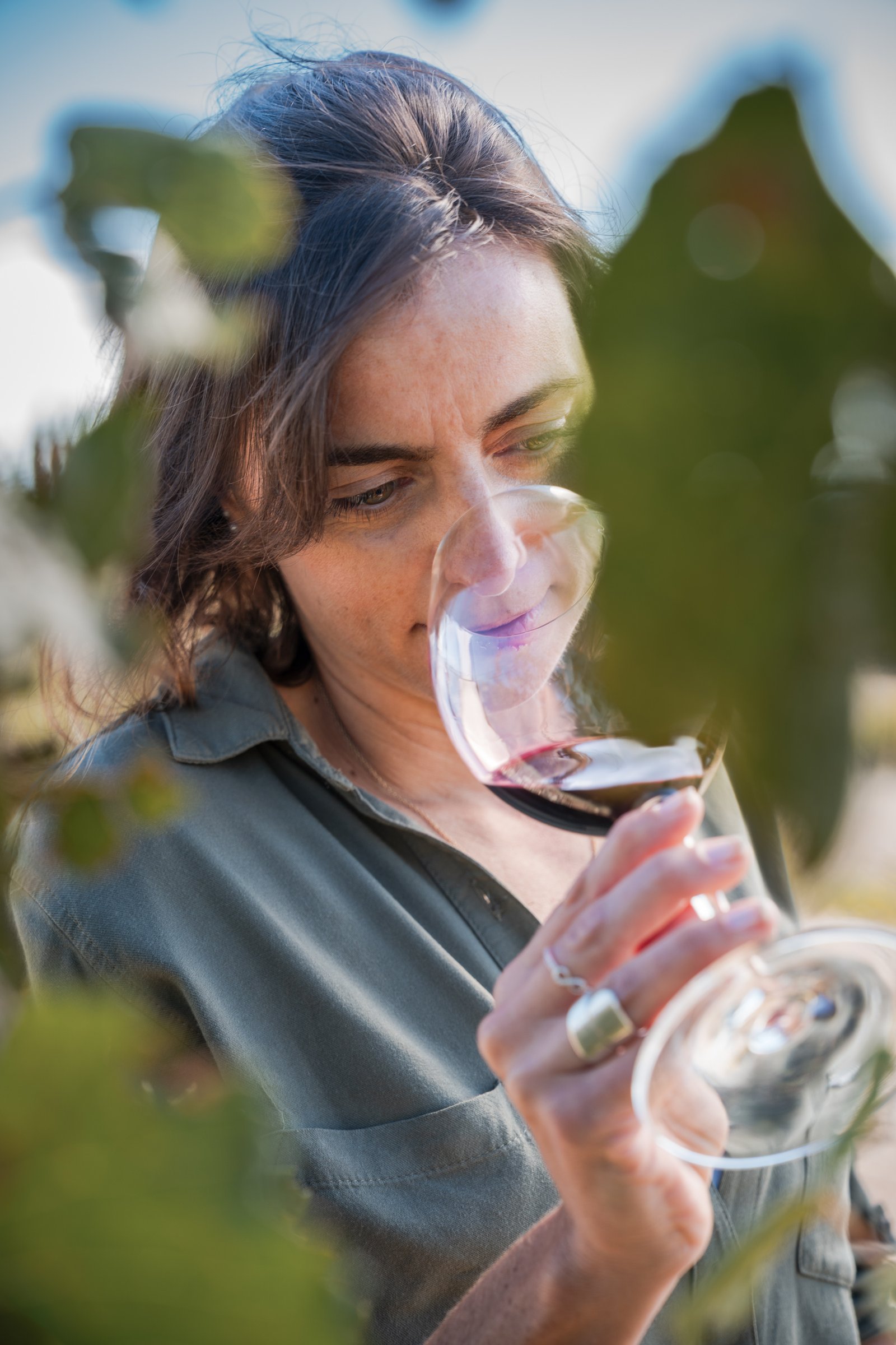 Juliana Bevilacqua catando una copa entre las viñas